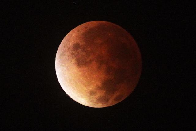 La Luna comienza a tomar color rojo a medida que la sombra de la Tierra la va cubriendo. EFE